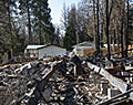 Debris. Woman on porch. Aftermath of Camp Fire. Magalia, California.